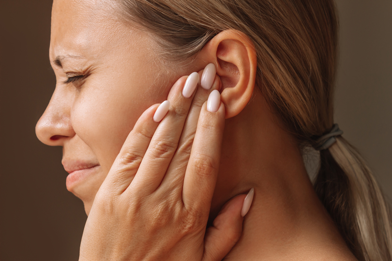 Woman with headache because of Tinnitus